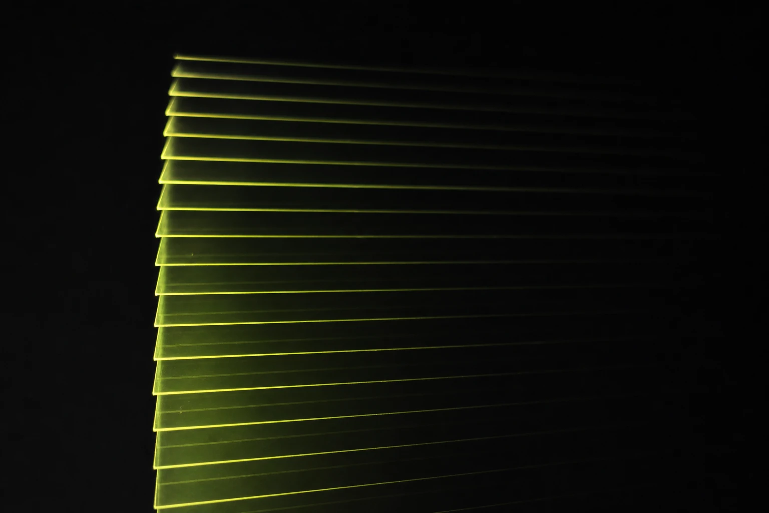 Layers of smoked acrylic lit edge-on, each edge glowing as a fine line receding into darkness.